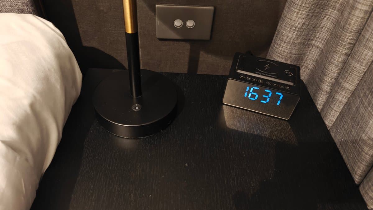 A bedside digital clock showing 16:37.