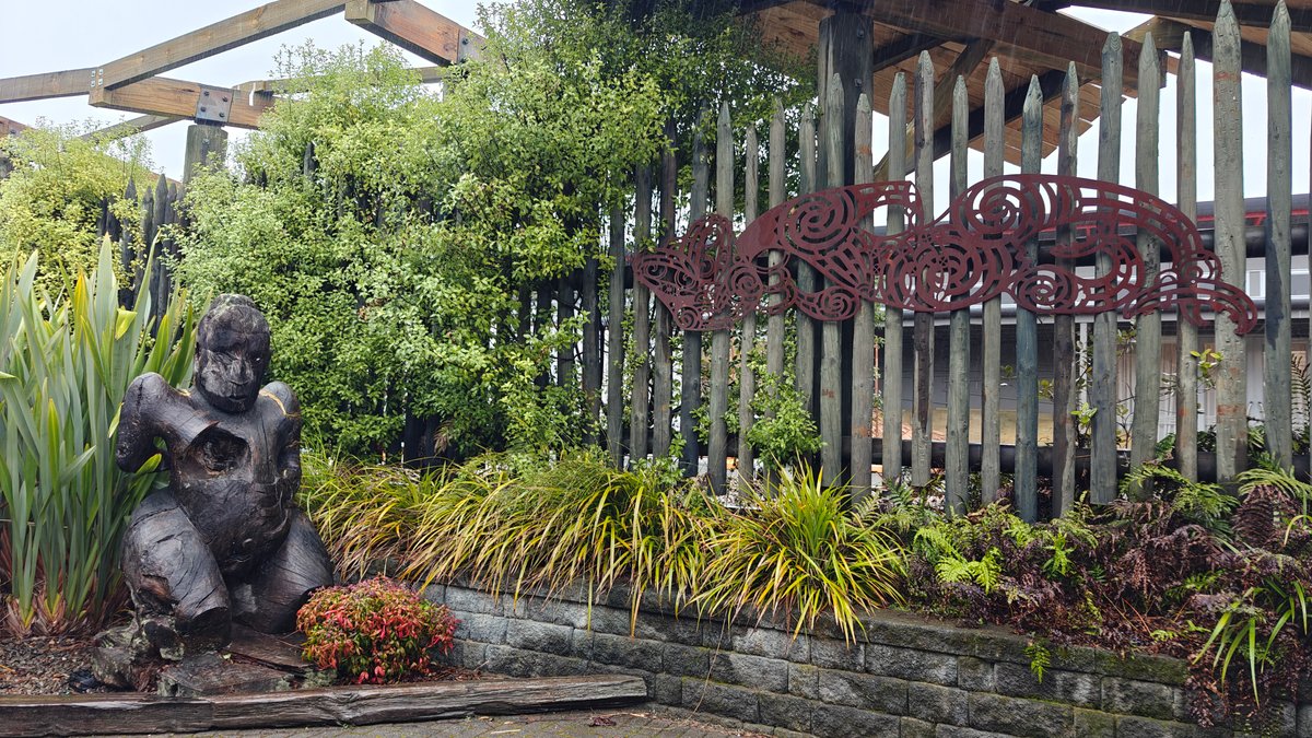 A bronze figure set among flax and planting