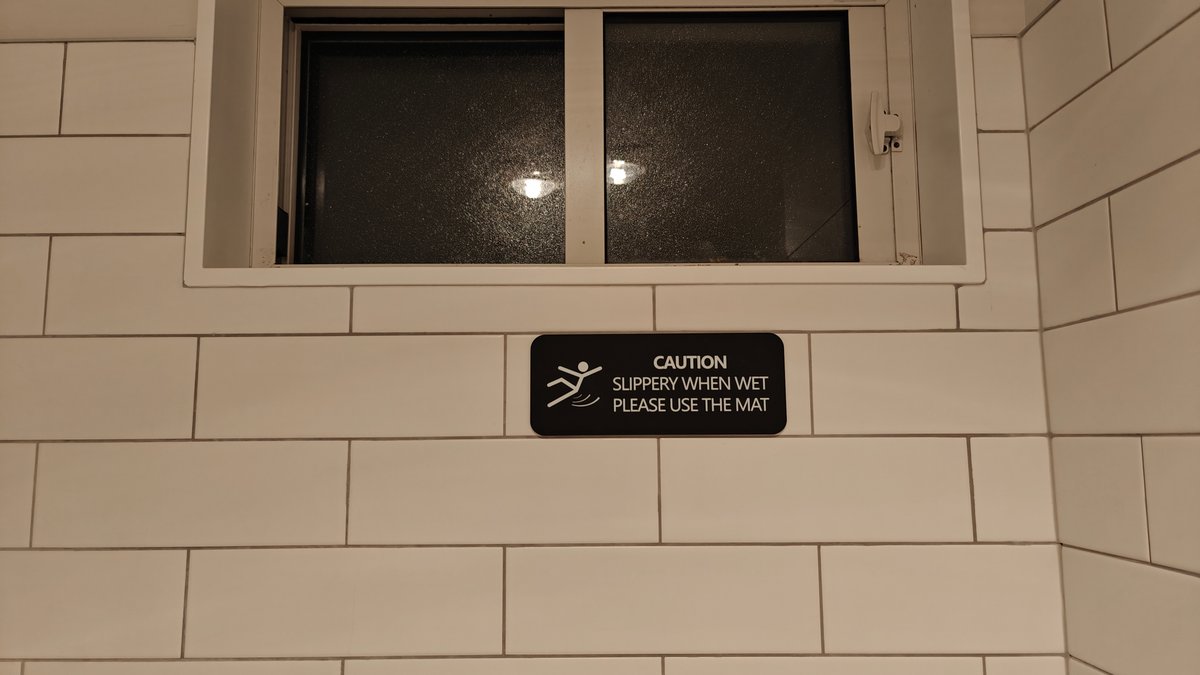 A caution sign below the window reading slippery