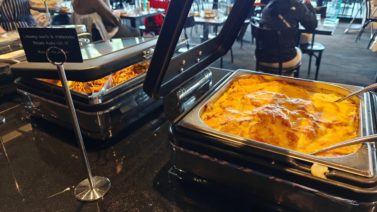A chafing tray of a yellow sauced dish.