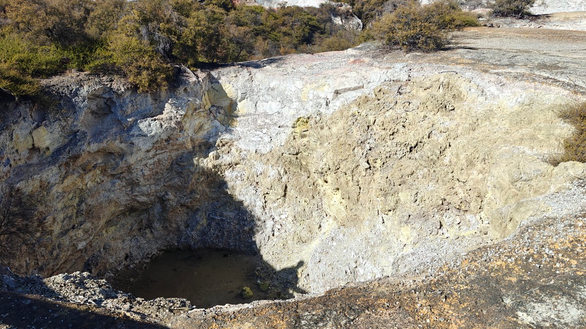 A crater with pale mineral walls and dark