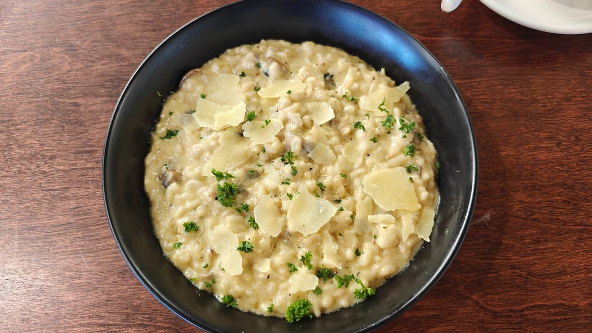A dark bowl of creamy risotto flecked with