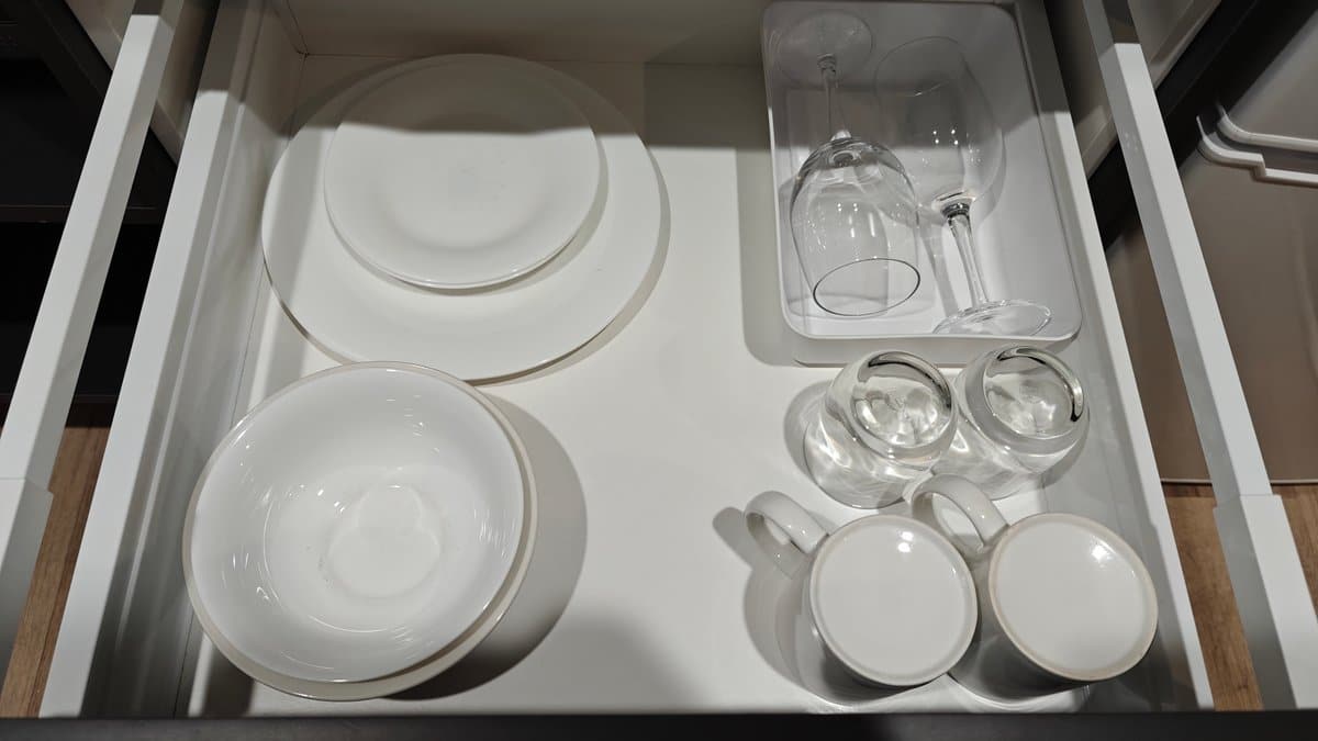 A drawer of plates, bowls and glassware.