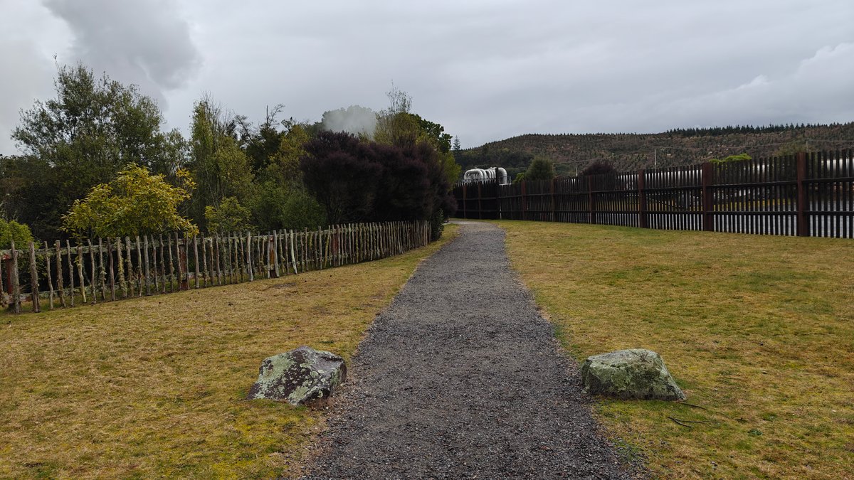 A gravel path running between post and rail
