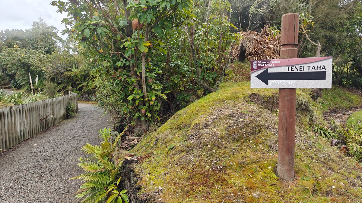A gravel path with a carved direction post