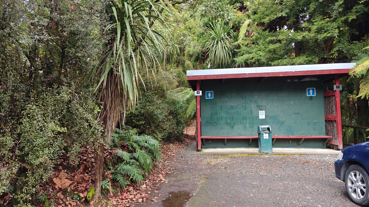 A green painted shelter set back in the