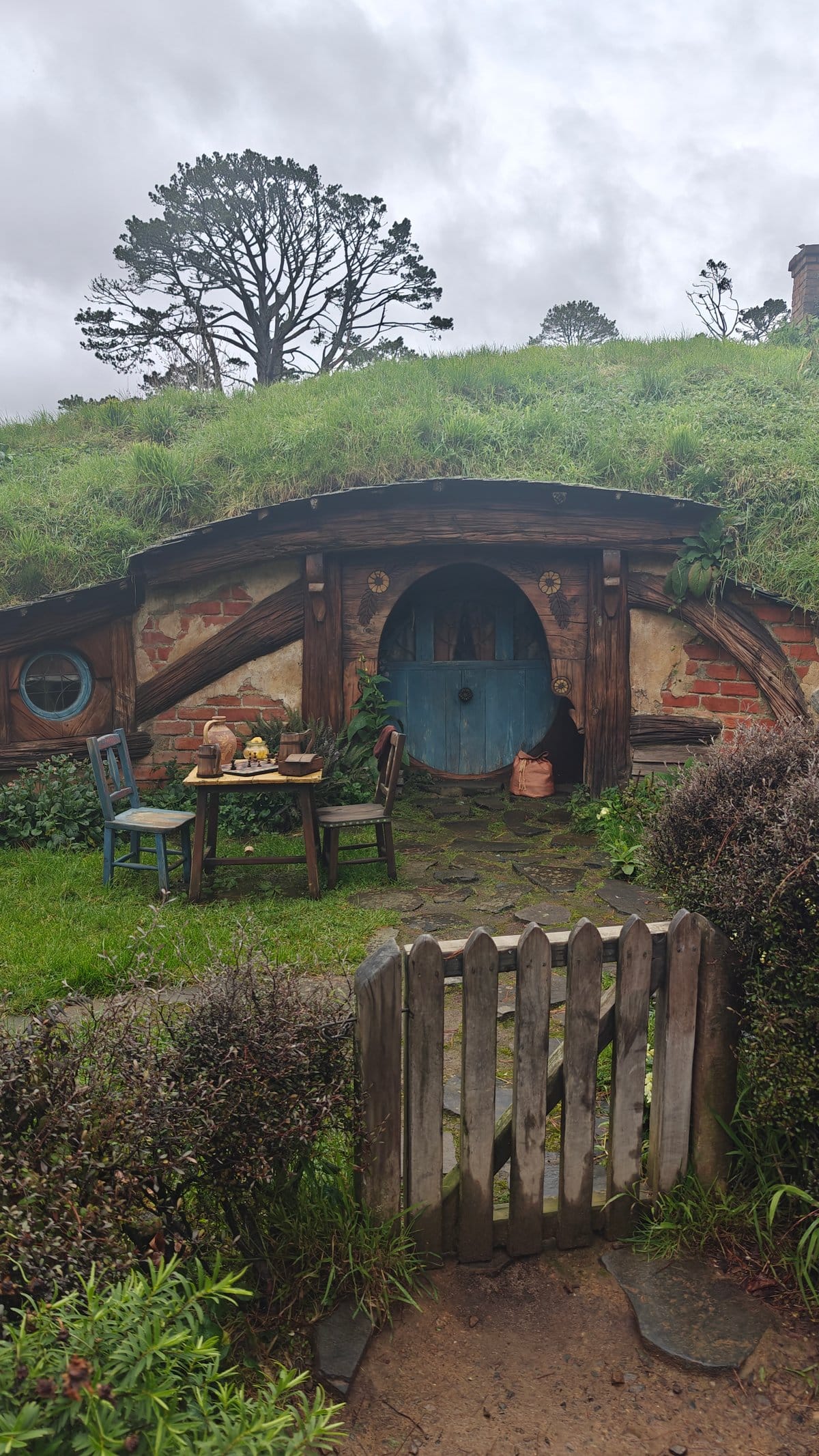 A hobbit hole with a blue door reached