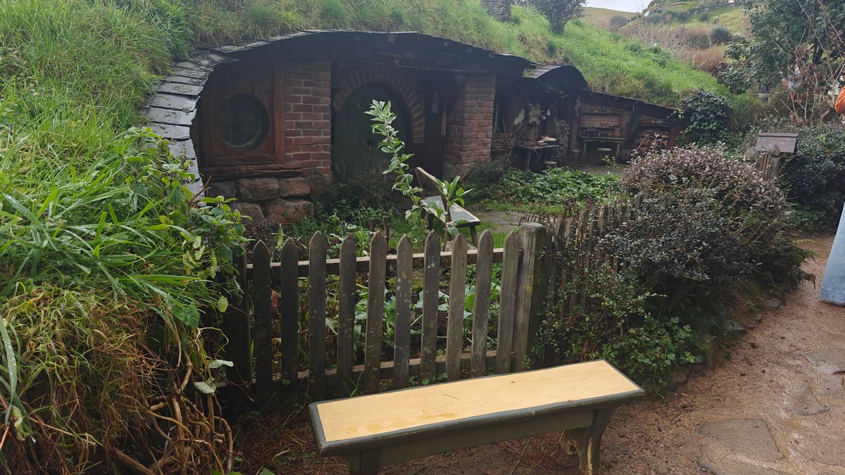 A hobbit hole with a picket fence and