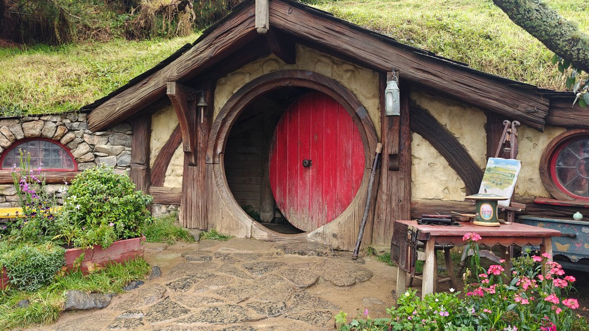 A hobbit hole with a red round door