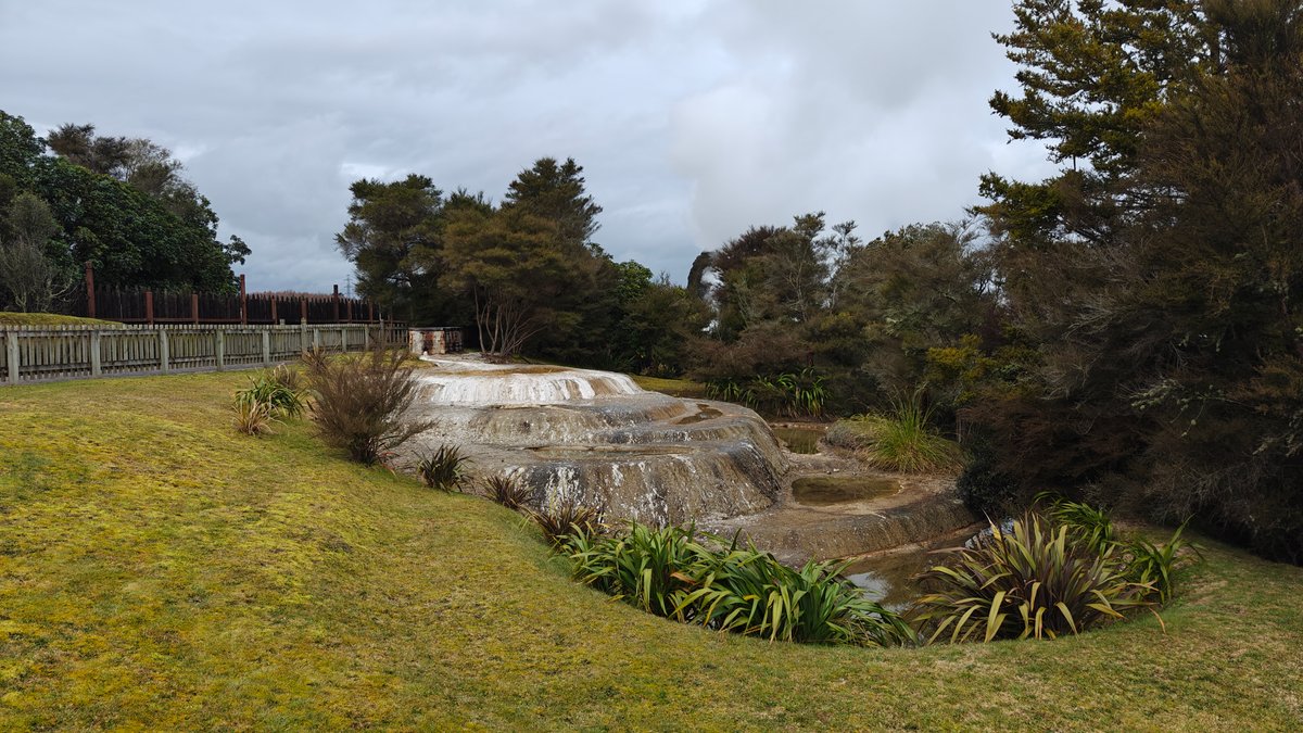 A pond with a sinter mound rising beside