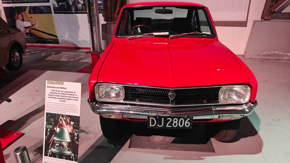 A red saloon car on display with the