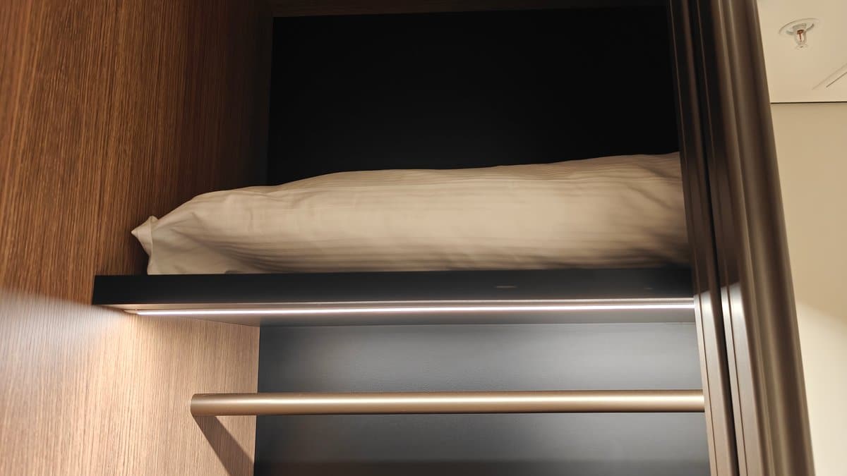 A spare pillow on the upper shelf beside