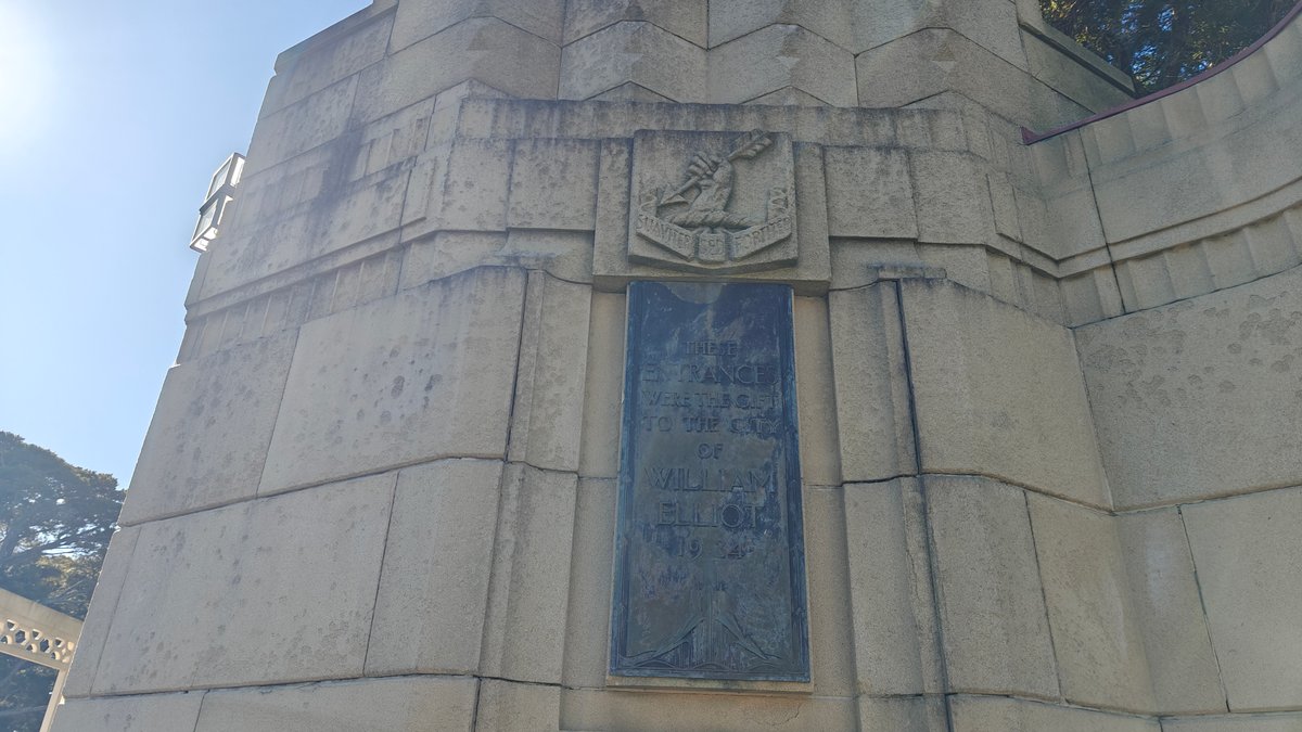 A stone memorial pylon at the gates carrying