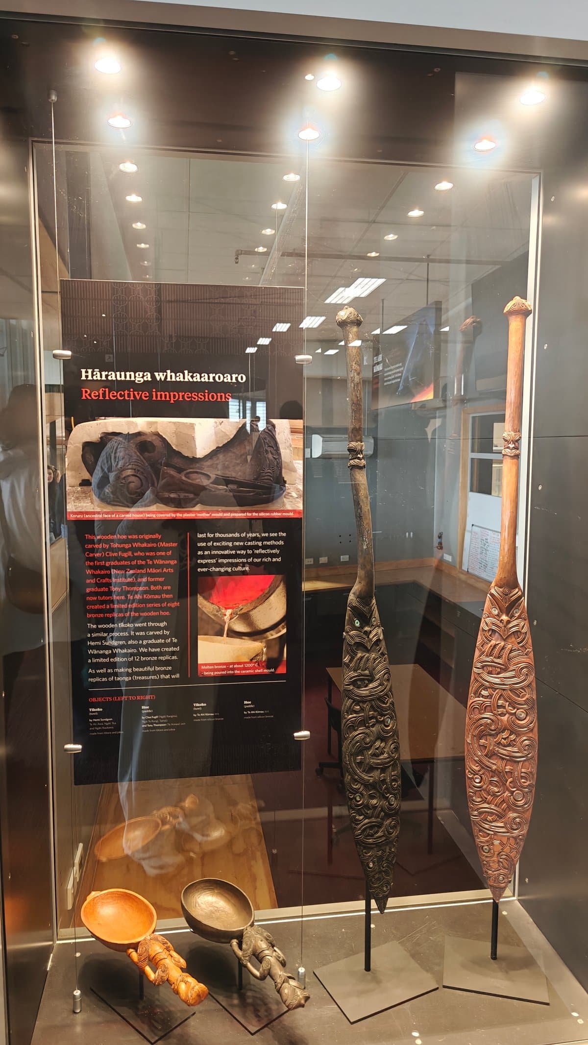 A tall case holding a carved staff and