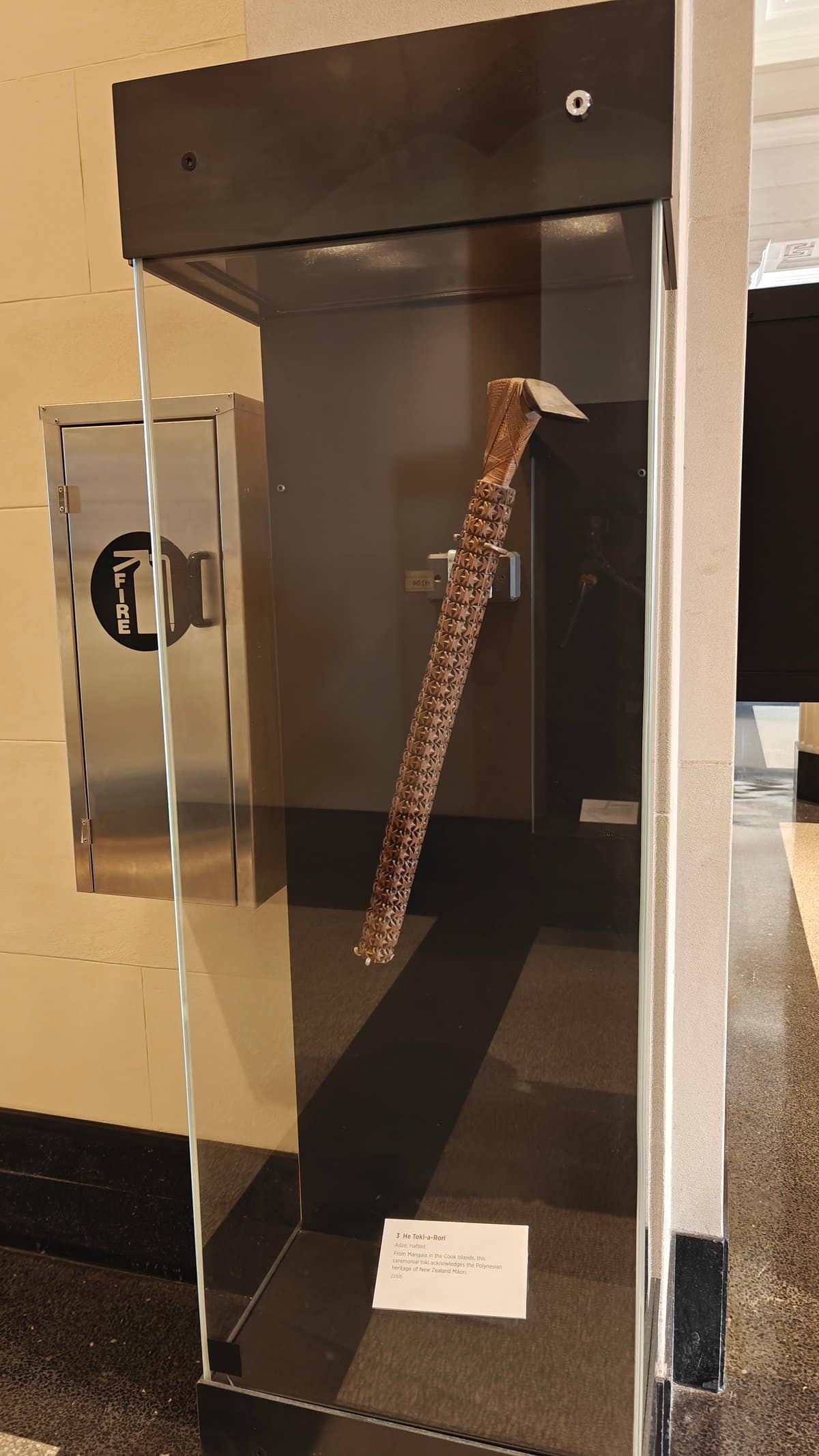 A tall glass case holding a carved wooden
