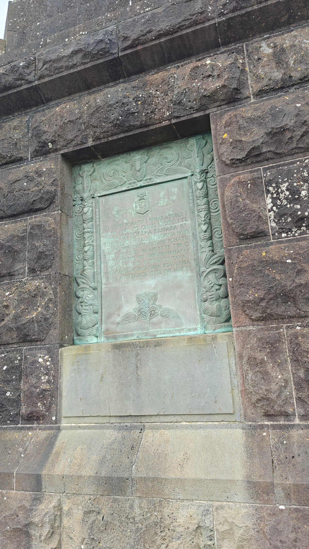 A third bronze panel set flush into the