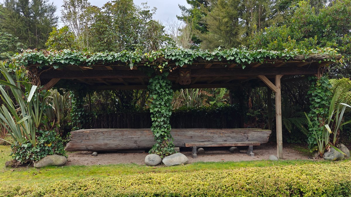 A timber shelter draped with ivy over a