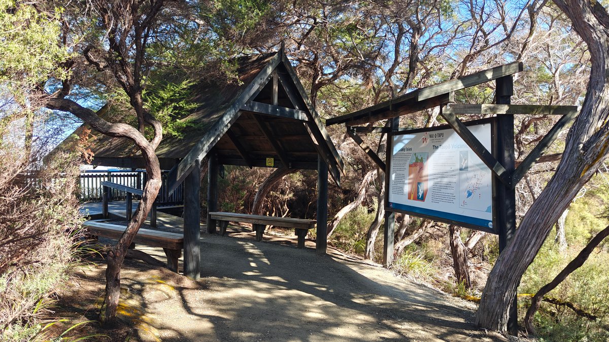 A timber shelter with interpretive boards and a