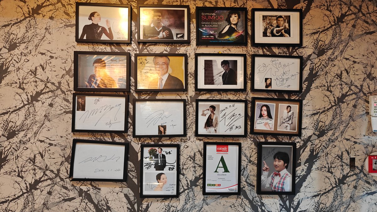 A wall hung with framed photographs and prints