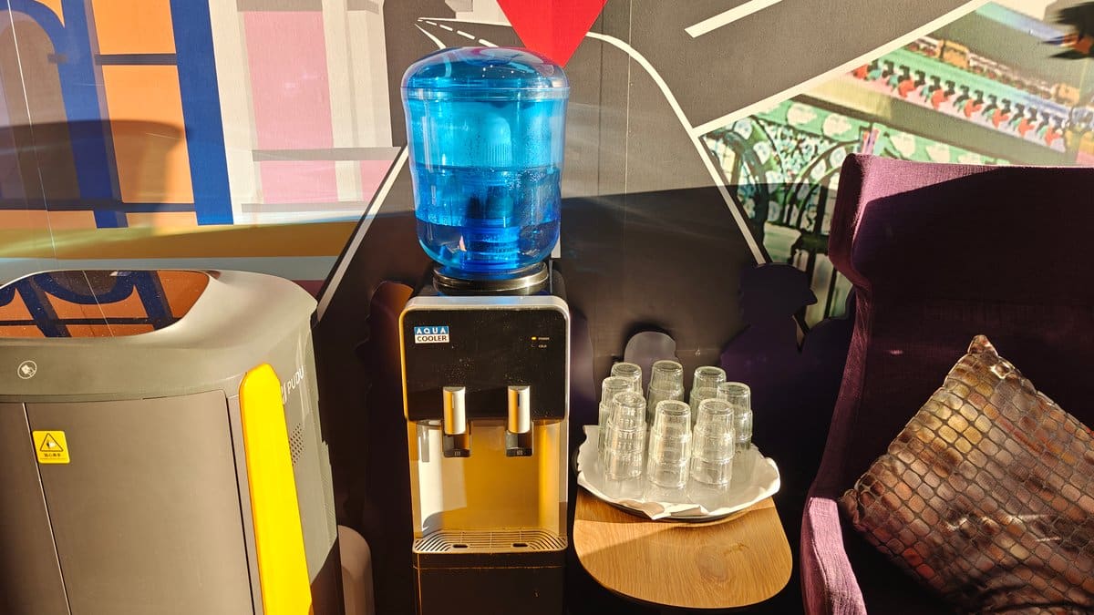 A water dispenser with glasses on a timber