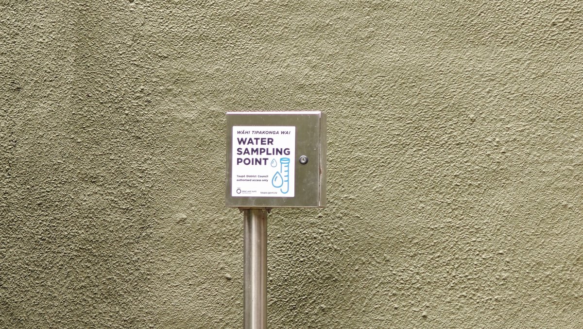 A WATER SAMPLING POINT sign mounted on a