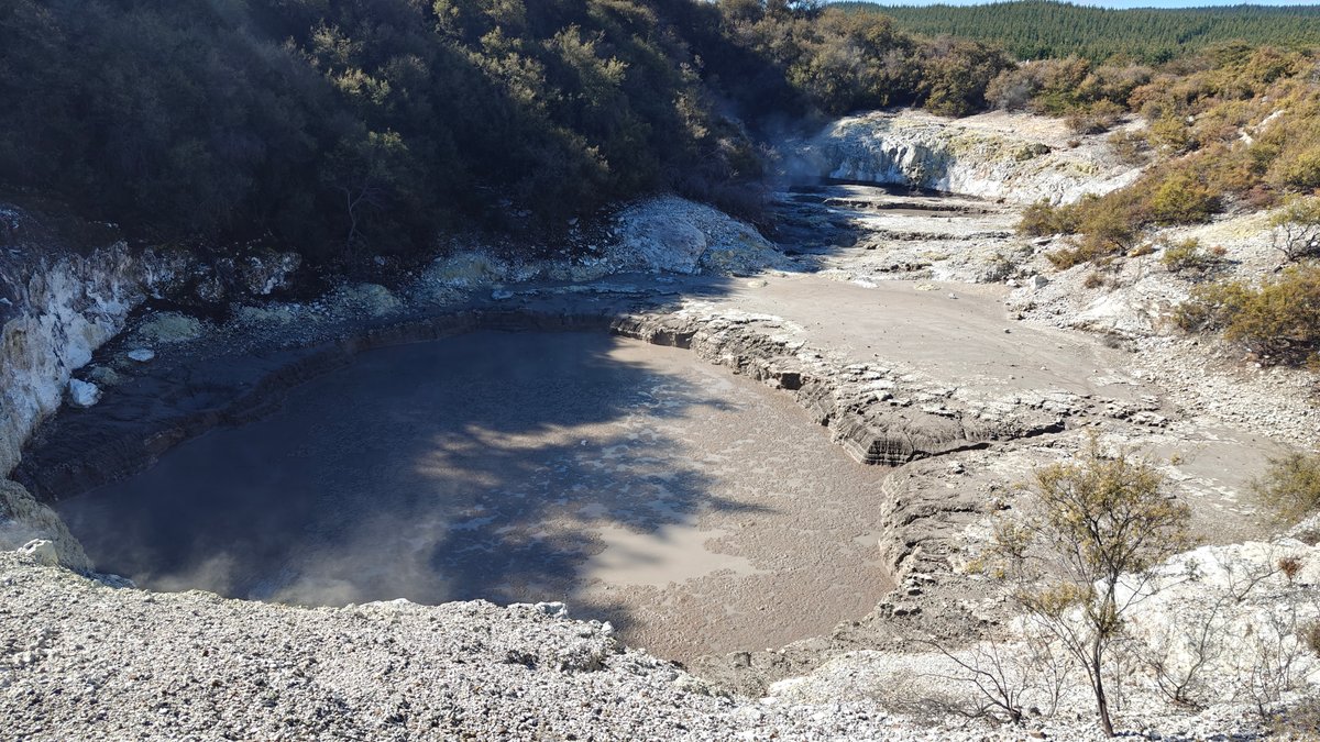 A wide mud crater filled with grey sludge.