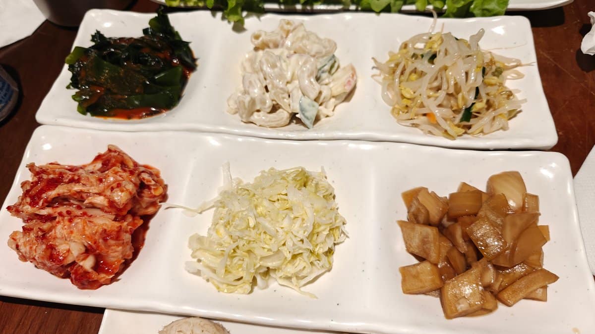 Banchan sides in small white dishes