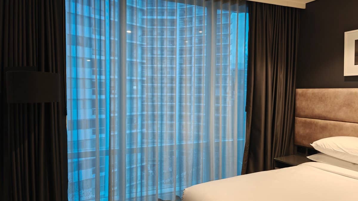 Bed beside blue curtains