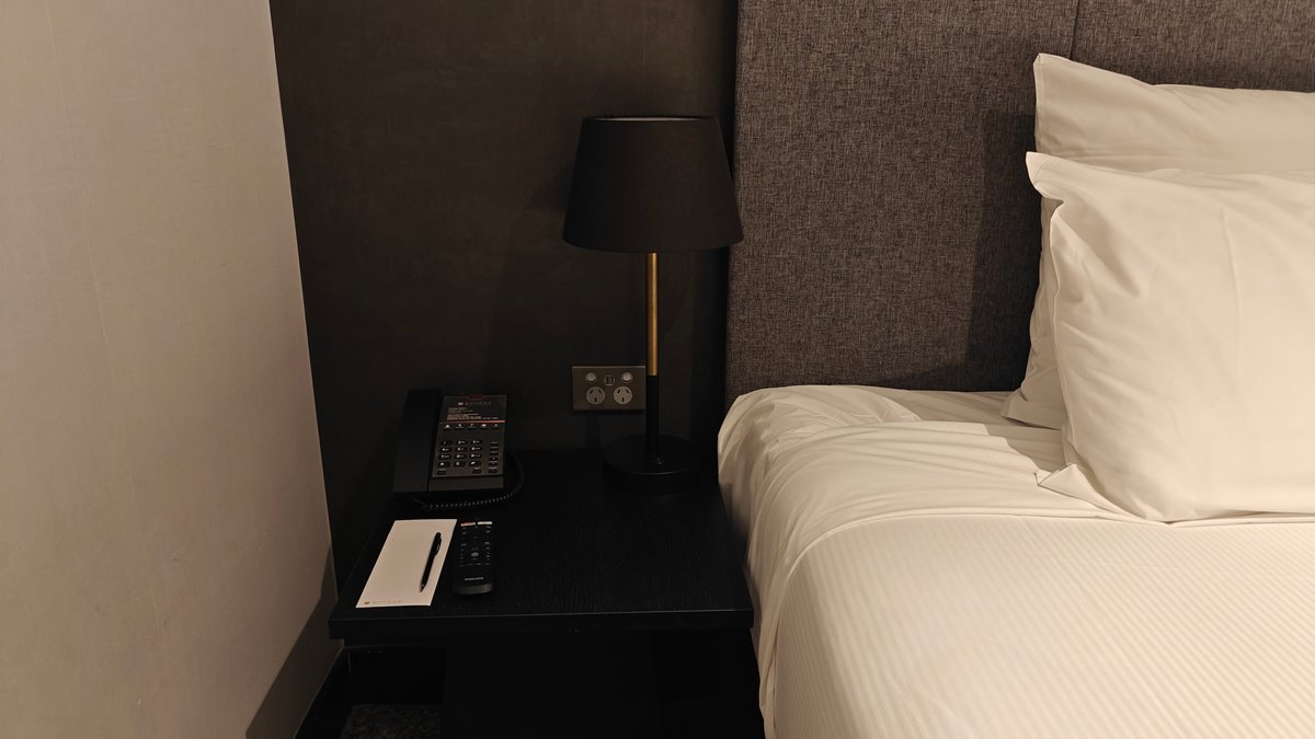 Bedside lamp beside the made bed
