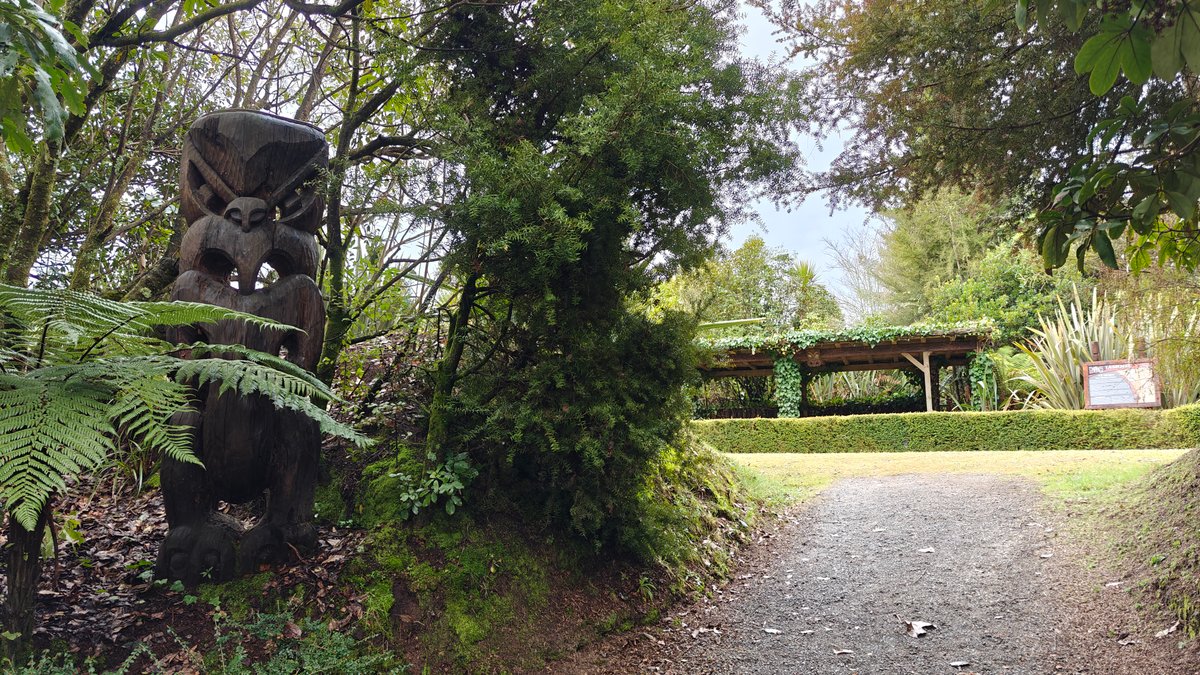 Carved pou beside village path