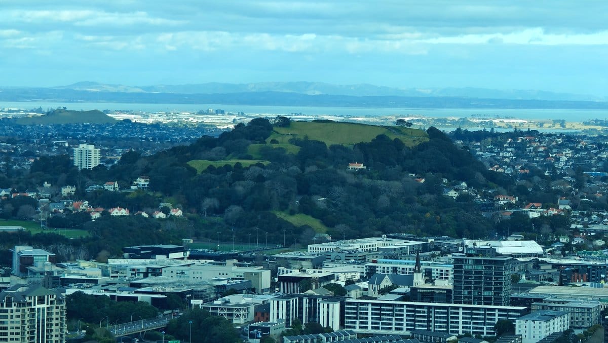 Green volcanic cone above suburbs