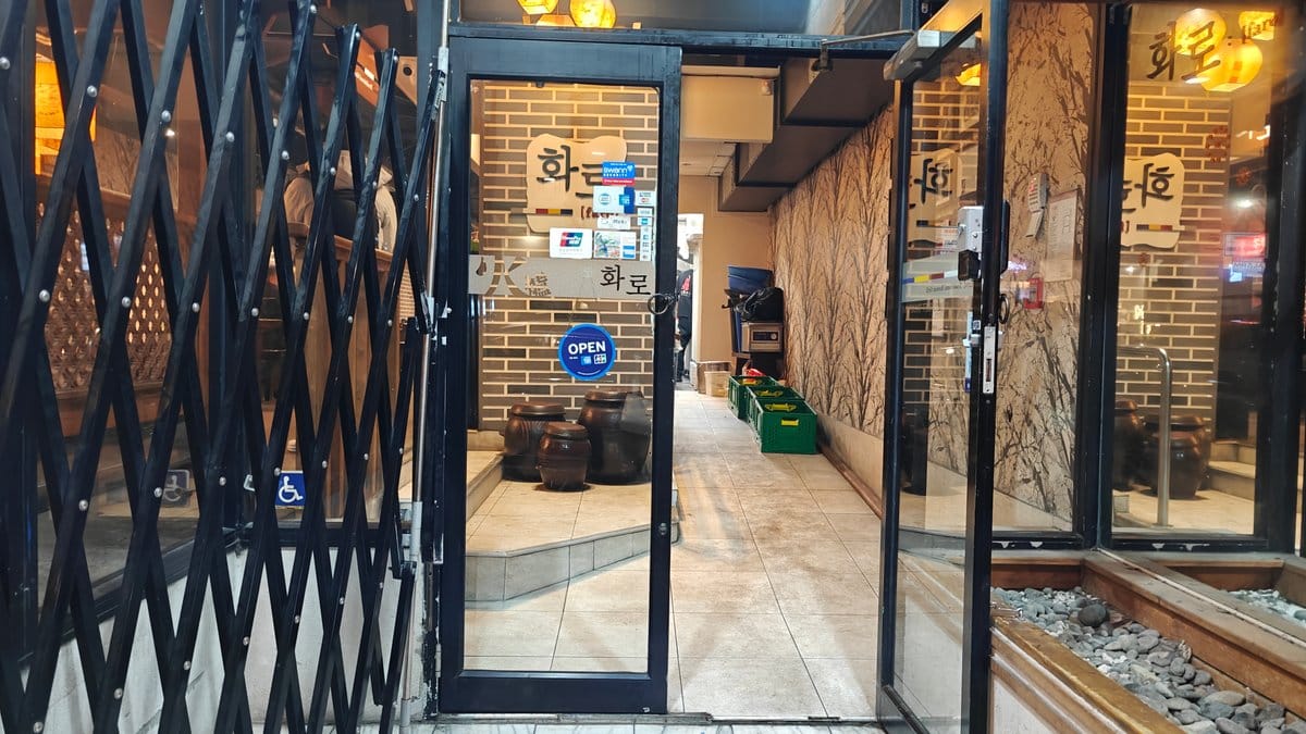 Lit entrance doors on wet footpath