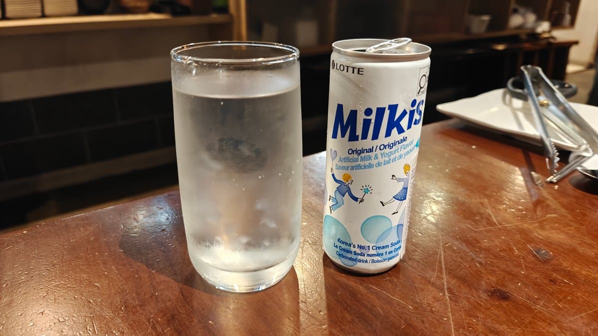 Milkis can beside a water glass