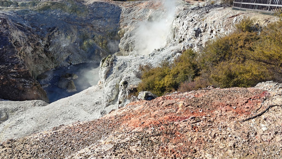 Orange-stained crater lifting steam