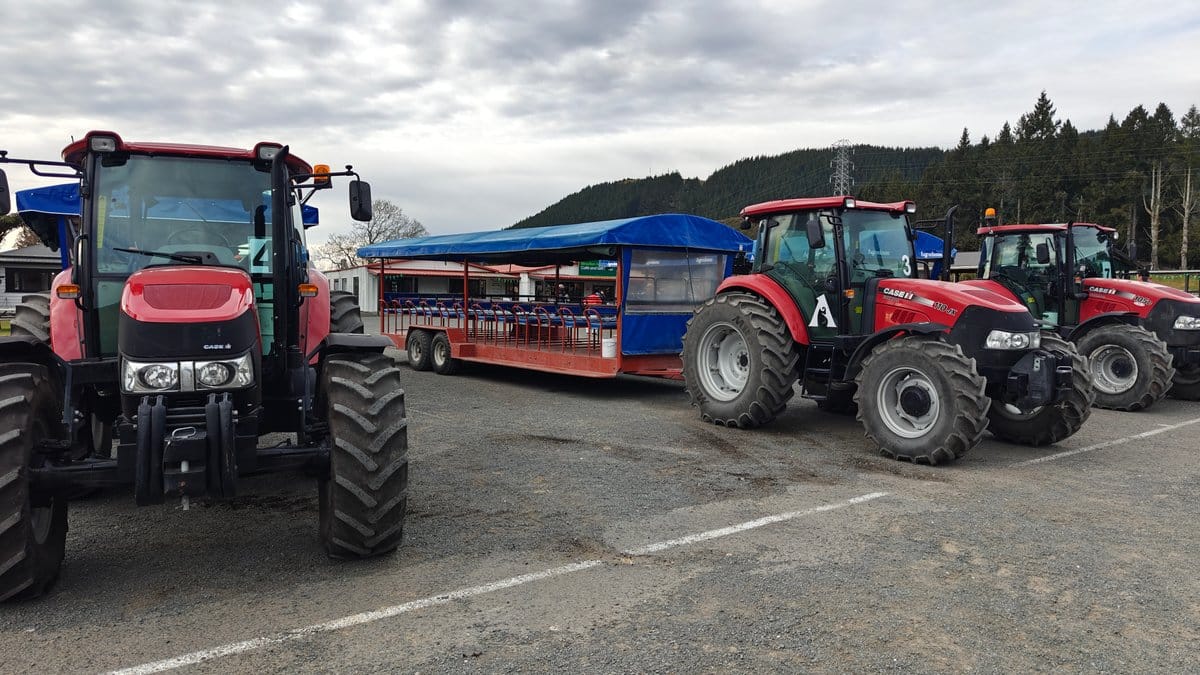 Red tractors and a trailer parked in the