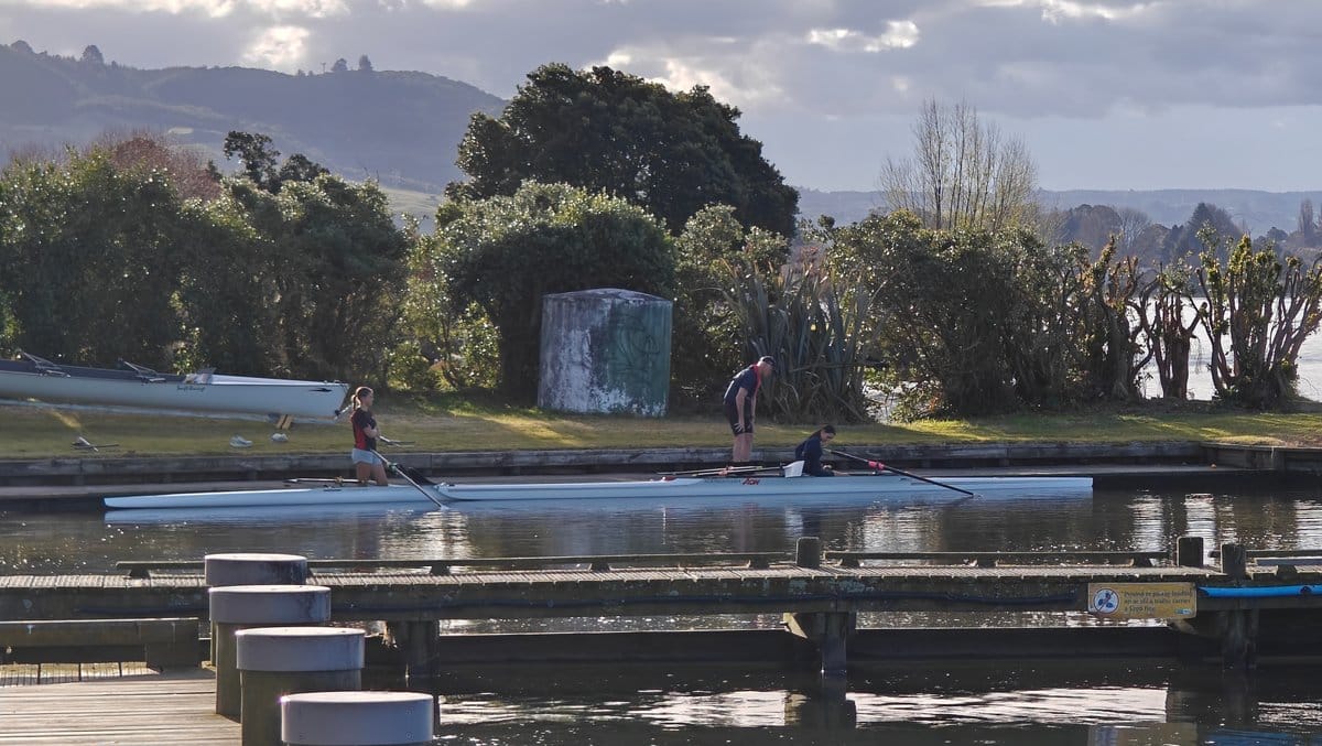 Rowing shells drawn up beside the boat shed