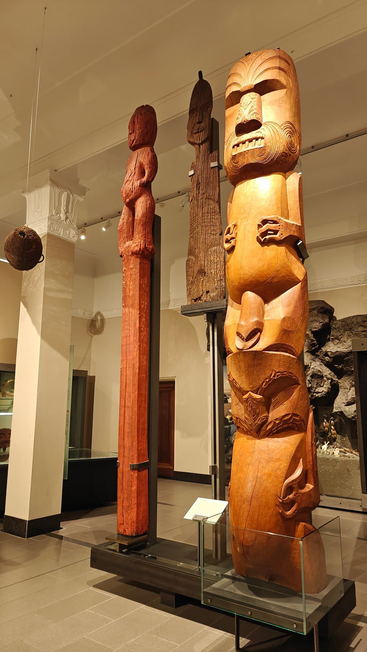Tall carved pou standing in gallery