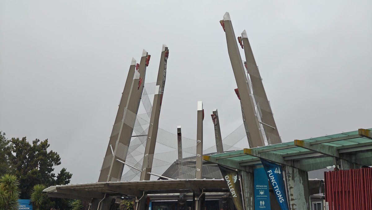 Tall carved timber poles standing at the entrance