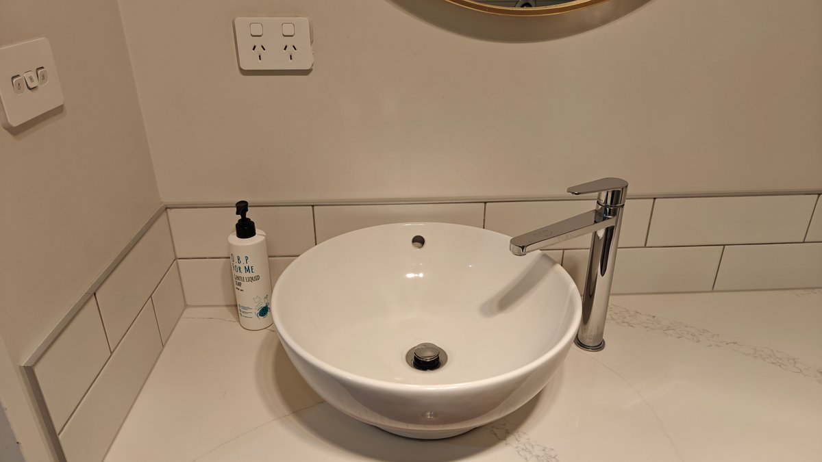 The basin close up with the soap dispenser
