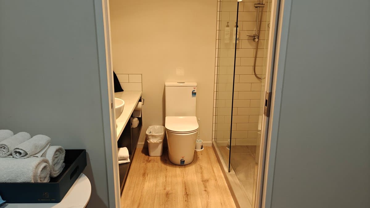 The bathroom seen from the room with towels