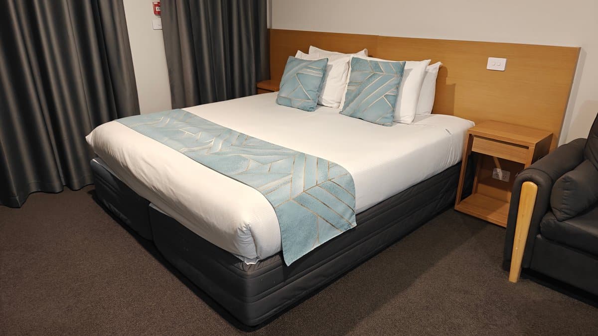 The bed with its timber headboard and an