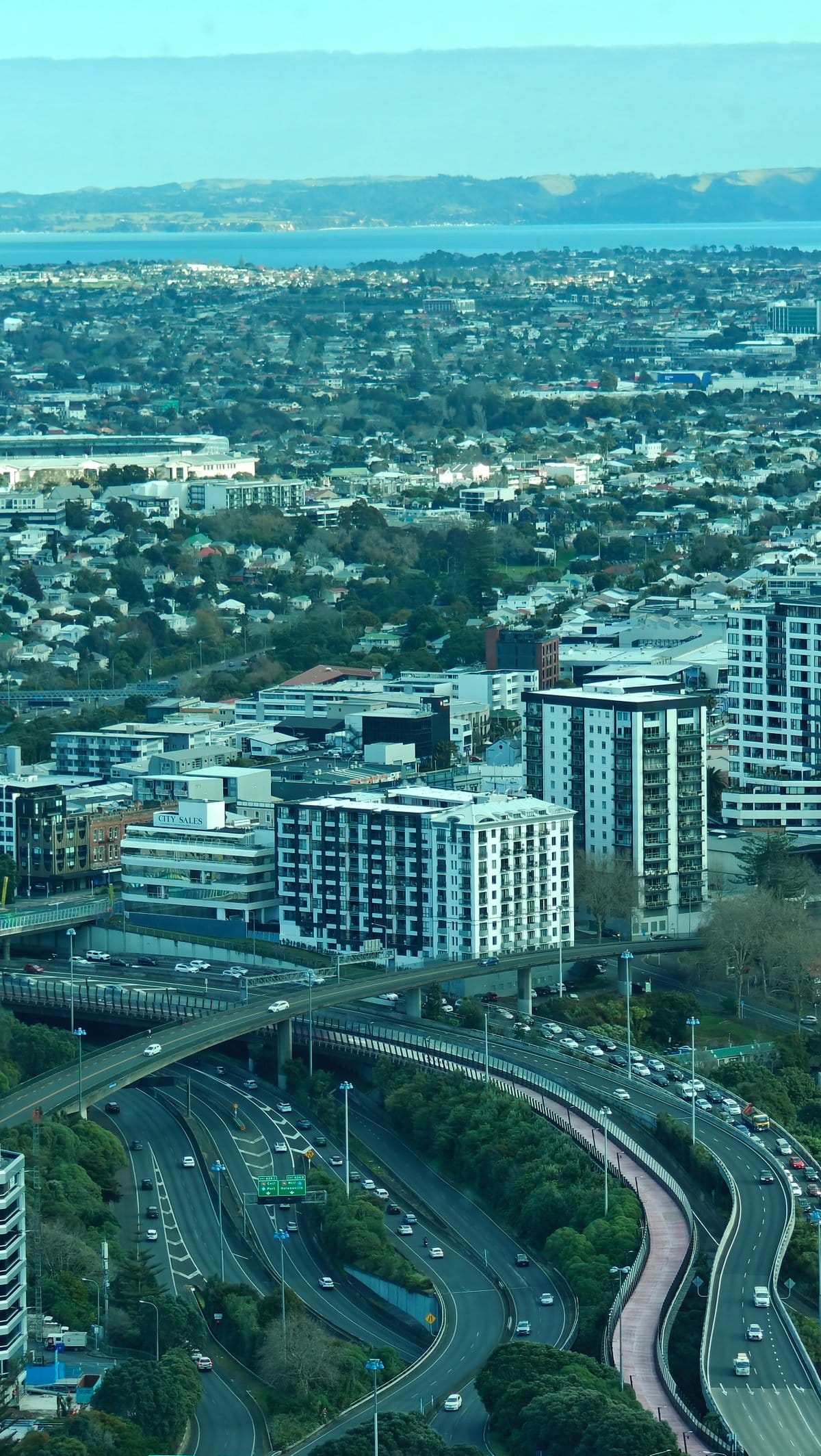 The motorway and suburbs with the harbour beyond.