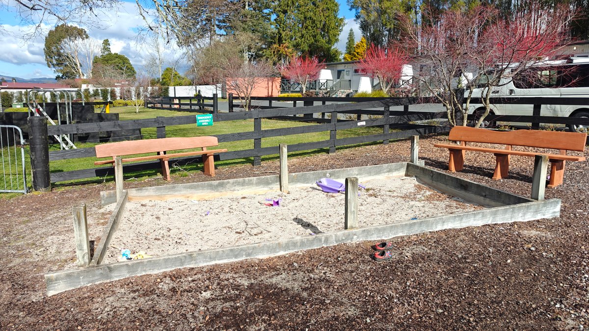 The play area with timber picnic tables set