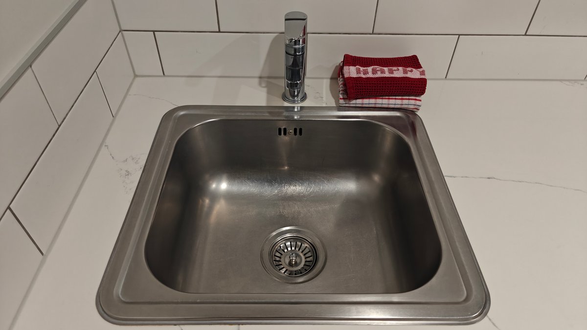 The stainless sink set into the stone kitchen