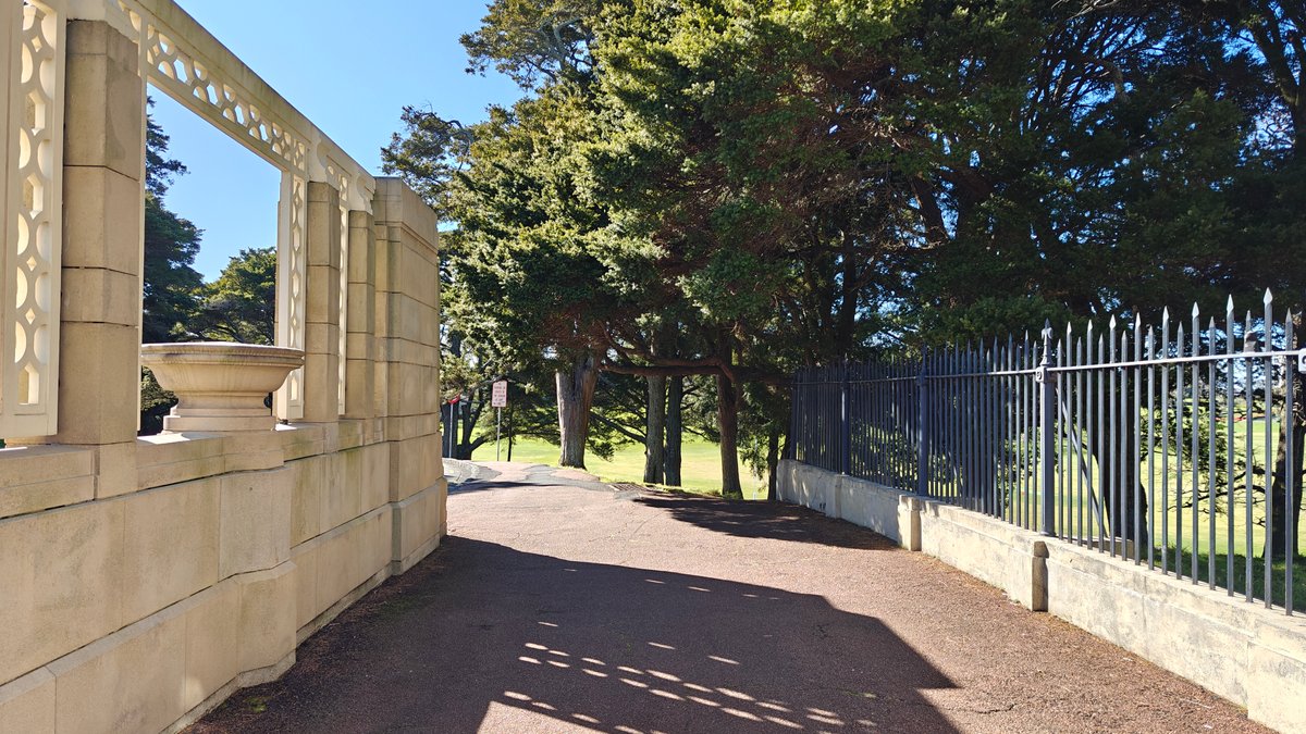 The stone wall and iron railings running along