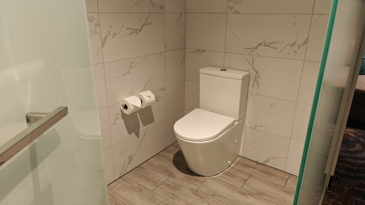 The toilet in its tiled recess with the