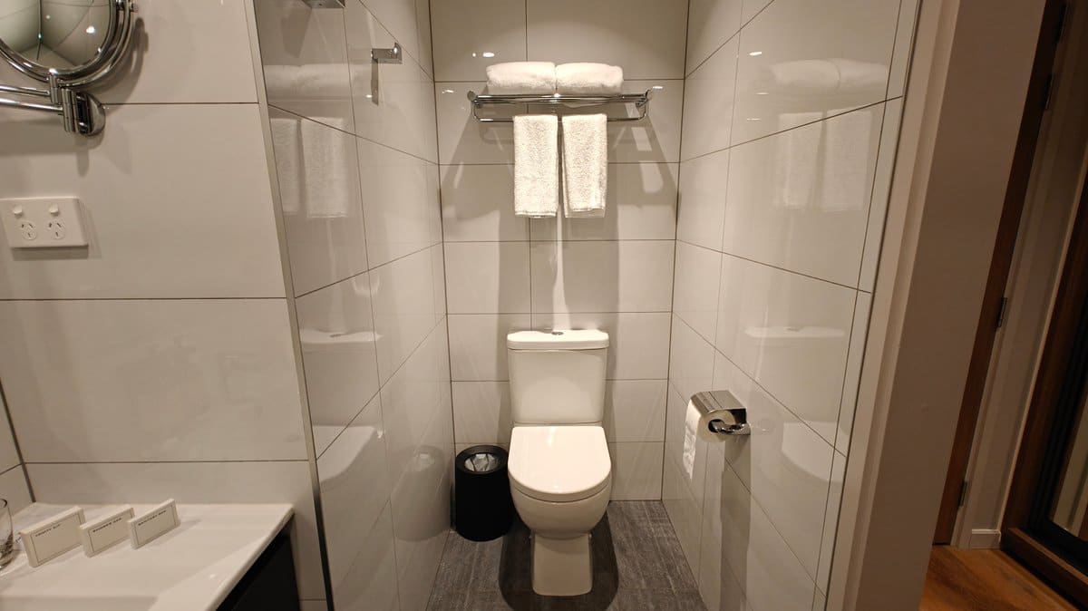 The vanity and toilet with towels stacked between