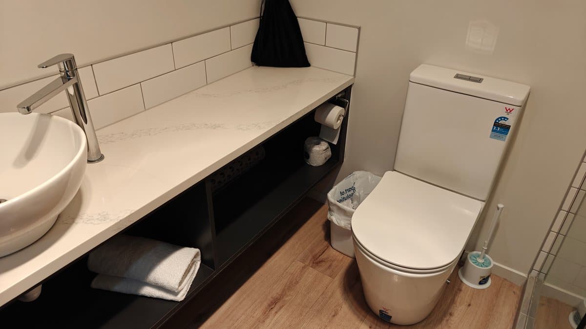 The vanity with towels stacked below and the