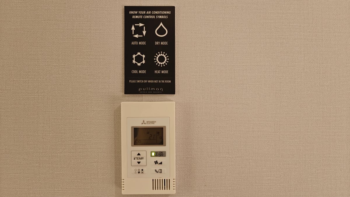 The wall-mounted climate control panel with its Mitsubishi
