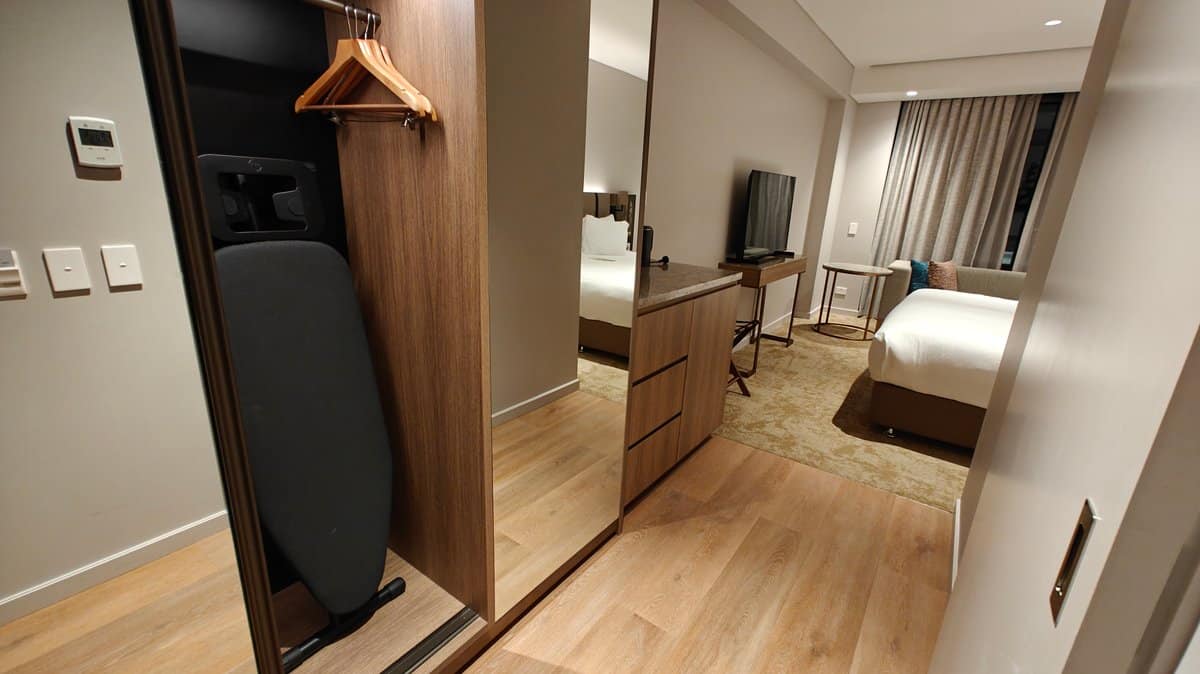 The wardrobe with the ironing board stowed against